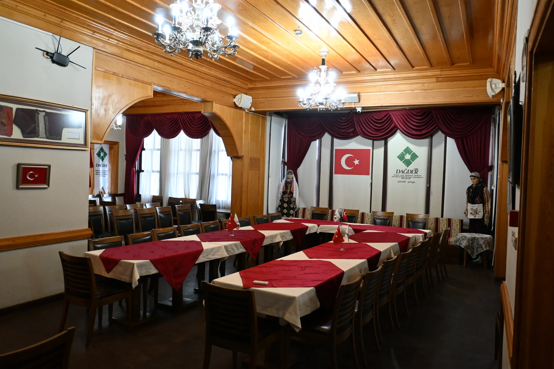 Toplantı salonu: kırmızı-beyaz örtülü masalar ve avize